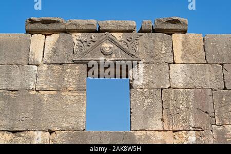 In pietra basaltica finestra e splendidamente scolpito sull'architrave del l'antica sinagoga di baraam parco nazionale in Israele su un cielo sfondo blu Foto Stock