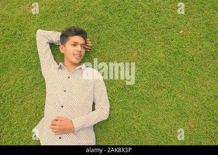 Ritratto di giovane indiano ragazzo adolescente di relax presso il parco Foto Stock