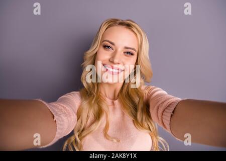 Foto di divertenti lady rendendo selfies parlando di skype con amici che mostra la nuova usura piane casual pullover isolato grigio colore di sfondo Foto Stock