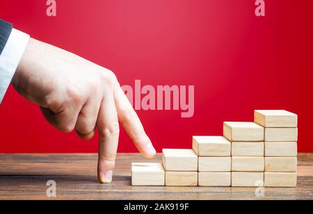 Imprenditore salite a mano di carriera di successo. Andando su un nuovo livello. Il progresso e la crescita professionale. Nomina di un dipendente in una nuova posizione Foto Stock