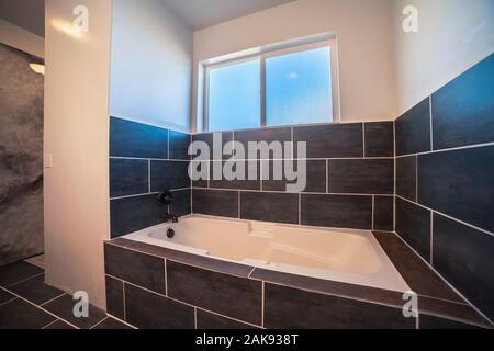 Bagno moderno con il grigio scuro di piastrelle in casa Foto Stock