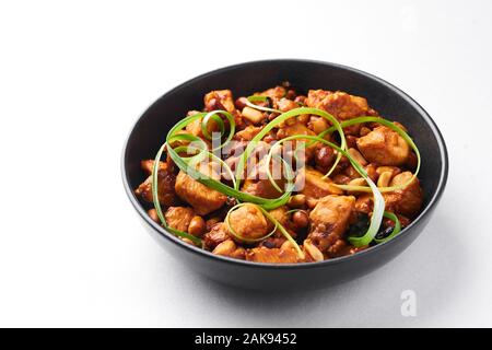 Kung Pao o pollo Gong Bao Ji Ding isolati su sfondo bianco. Sichuan Kung Pao è la cucina cinese è piatto con carne di pollo, peperoncino, noccioline Foto Stock