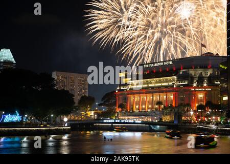 Fuochi d'artificio esplodere oltre il Fullerton Hotel come abitanti di Singapore festeggiare il Capodanno cinese Foto Stock