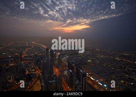 DUBAI, Emirati Arabi Uniti - 19 novembre 2019: Dubai città illuminata ad alto angolo di visione con grattacieli in una sera Nuvoloso Foto Stock