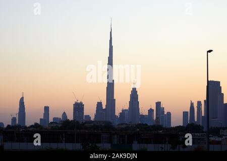 Skyline di Dubai con il Burj Khalifa grattacielo al tramonto, cielo chiaro negli Emirati Arabi Uniti Foto Stock
