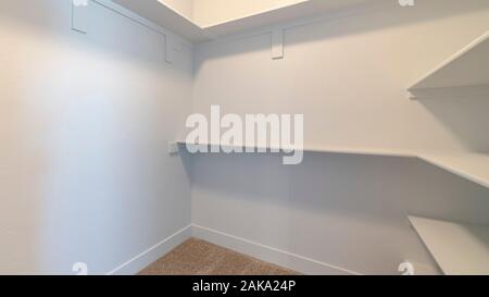 Panorama telaio bianco vuoto di ripiani all'interno di una passeggiata in armadio Foto Stock