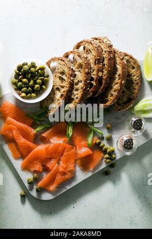 Pane di segale con salmone affumicato su una scheda in marmo. inverno snack. Foto Stock