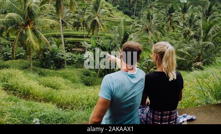 Giovane om Tegalalang riso Terrazza campi e alcune palme tutto intorno, Ubud, Bali, Indonesia Foto Stock