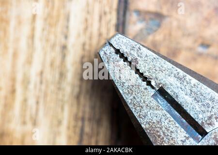 Vecchio metall rusty pinza su uno sfondo di legno Foto Stock