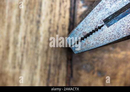 Vecchio metall rusty pinza su un piano di lavoro in legno. Carpenter strumenti. Foto Stock