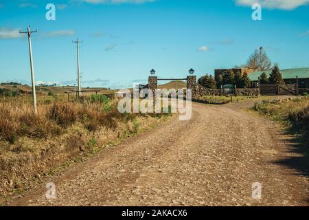 Strada sterrata e gate di una cascina in aree di pianura chiamato Pampa vicino Cambara do Sul. Una città con una naturale Attrazioni turistiche nel sud del Brasile. Foto Stock