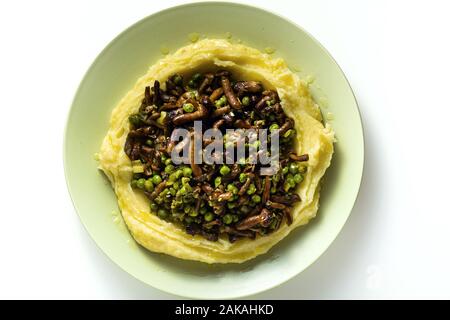 Purè di patate con funghi e piselli verdi sul tavolo. sano cibo a molla Foto Stock