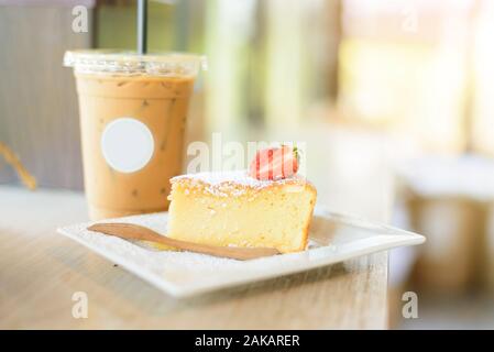 dolce con fragola e caffè di ghiaccio sul tavolo Foto Stock