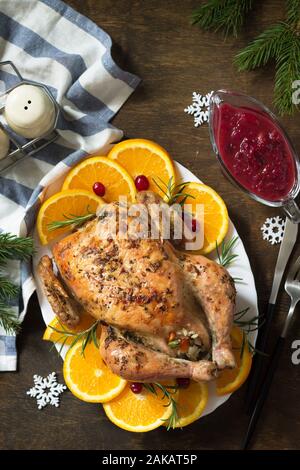 Concetto di Natale o Capodanno cena arrosto di tacchino ripieni di riso e salsa di mirtilli su un tavolo di legno. Vista dall'alto. Foto Stock