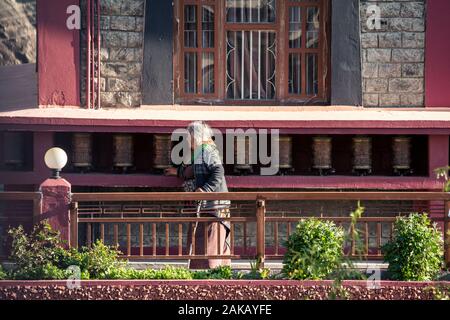 Vecchia donna la filatura ruote della preghiera in Kag contese Thupten Samphel Ling monastero nel villaggio di Kagbeni, Mustang distretto, Nepal. Foto Stock