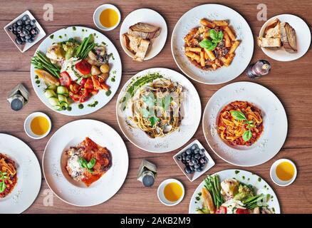 Alcuni piatti della deliziosa cucina italiana sulla texture di sfondo di legno, vista dall'alto Foto Stock