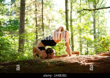 Donna fare yoga in foresta, Tacoma, nello Stato di Washington, USA Foto Stock