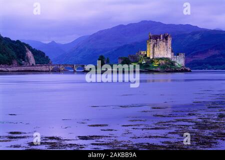 Eilean Donan Castle sull isola nel lago e il ponte al tramonto, Highlands, Scotland, Regno Unito Foto Stock