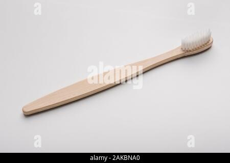 Bagno essentials, plastica prodotti gratuiti. Eco di bamboo naturale spazzolino da denti su sfondo bianco, panorama verticale Foto Stock