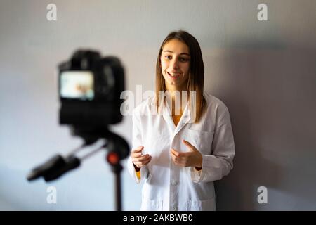 Medico donna la registrazione di un assistenza sanitaria e di assistenza video per il suo Vlog di medicina. Concetto di cure mediche e di tecnologia. Foto Stock