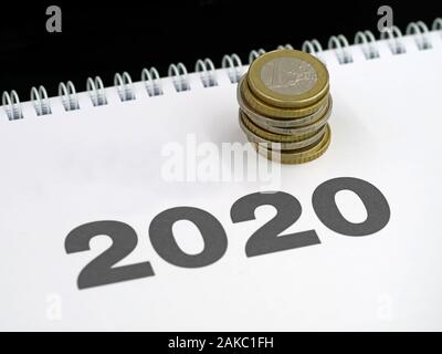 Pila di monete in euro sul calendario 2020 il concetto di spese o il pagamento delle imposte, cambiamento di costi per il nuovo anno Foto Stock