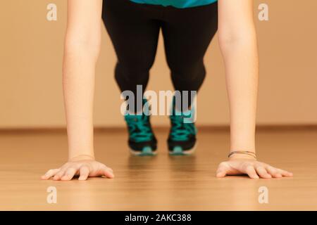 Stock Foto di una giovane donna facendo push-up a casa Foto Stock
