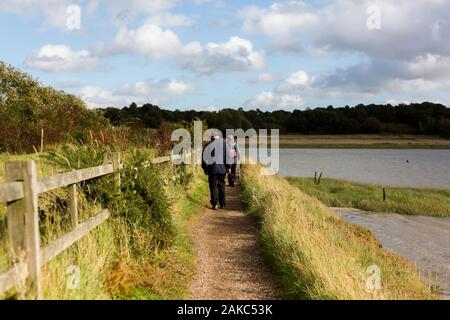 Una coppia senior godendo di una passeggiata lungo il fiume Deben su una soleggiata giornata collezione autunno Foto Stock