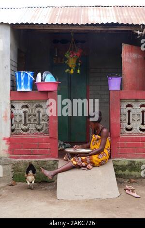 Madagascar, Diana regione, Marosely village, una donna di riso di smistamento di fronte alla sua casa Foto Stock