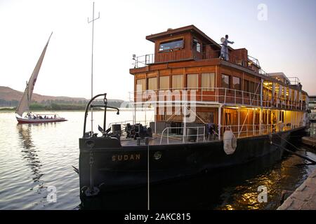 Egitto Alto Egitto, Valle del Nilo, la nave a vapore il Sudan, l'ultimo steamboat crociera sul Nilo, ormeggiata su una banca con una Feluca di attraversare il fiume in background Foto Stock