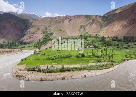 Tagikistan, Gorno-Badakhshan Regione autonoma, serpeggiante Fiume Piandj, verde delle culture e delle montagne del deserto, Afghanistan visto dal Tagikistan Foto Stock