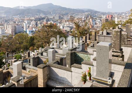Giappone, Isola di Kyushu, Regione di Nagasaki, città di Nagasaki, Sakamoto cimitero internazionale, tombe, epitaffi e città in background Foto Stock
