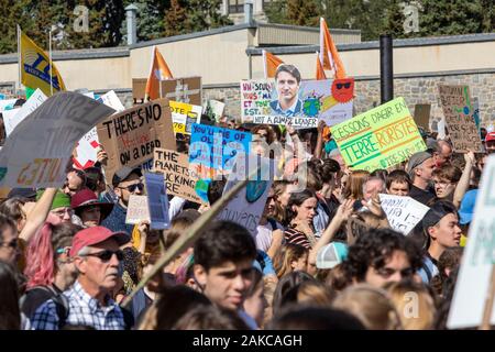 Canada, Provincia del Quebec e di Montreal, il mese di marzo per il clima, la processione, folla sventolano slogan segni, ritratto di il primo ministro canadese Justin Trudeau Foto Stock