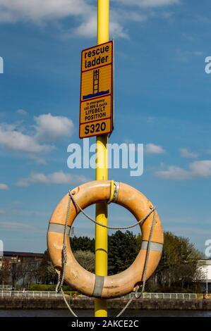 Lifesaver appeso in pole lungo le rive del fiume Clyde a Glasgow, Scozia Foto Stock