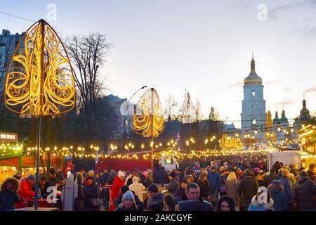 KIEV, UCRAINA - Gennaio 06, 2020: le persone che frequentano il nuovo anno e il mercatino di Natale in una vecchia città di Kiev, con Sophia Cathedral in background Foto Stock