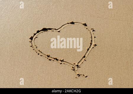 Forma di cuore disegnato nella sabbia in spiaggia Foto Stock