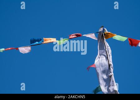 La preghiera buddista bandiere nel villaggio di Kagbeni, un ponte tra il basso e la Mustang superiore nella valle del Kali Gandaki river. Il Nepal. Foto Stock