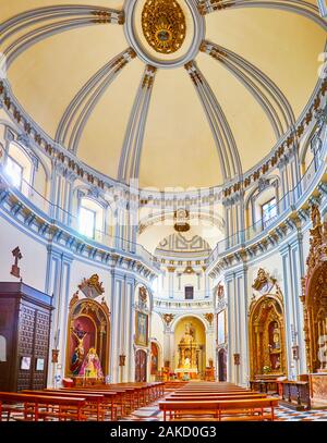 MALAGA, Spagna - 26 settembre 2019: La scenic interno di San Felipe Neri chiesa riccamente decorate cappelle, grande cupola interna e altare sul Settemb Foto Stock