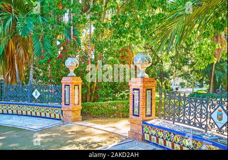 MALAGA, Spagna - 26 settembre 2019: La porcellana decor di stile andaluso corte di Malaga Park - i poli sono toppped con vasi ornamentali e ben Foto Stock