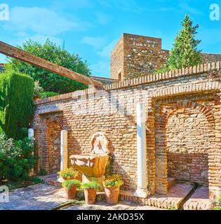 La vecchia pietra fontana potabile nel muro di mattoni di Alcazaba fortezza, Malaga, Spagna Foto Stock