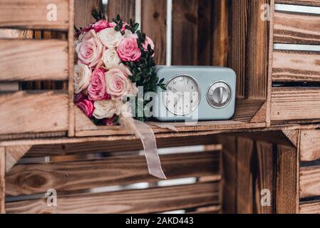 Wedding bouquet di rosa e rose bianche vicino con retro sveglia orologi. Foto Stock