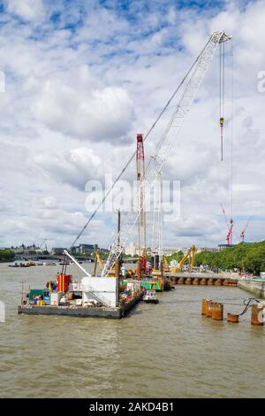 La Thames Tideway sotto regime di costruzione con macchinari pesanti su chiatte sul fiume, London, Regno Unito Foto Stock