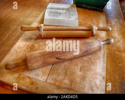 Due mattonelle di legno spolverate di farina bianca su un tagliere rustico. Ingredienti da forno e utensili da cucina. Foto Stock
