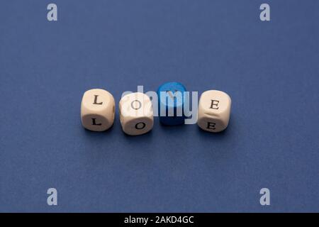 Amore messaggio parola scritta su blocchi di legno su sfondo blu, vista dall'alto. Foto Stock