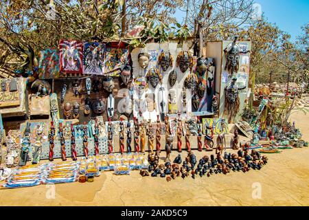 Isola di Gorée, Senegal- 22 aprile 2019: Bella colorata in legno bambole, statuette e maschere con tipici disegni senegalesi e semi di baobab. Si tratta di un Foto Stock