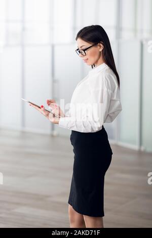Uno stile di vita attivo di etnia miste carriera business donna a piedi per un posto di lavoro in ufficio. Foto Stock