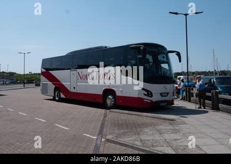 Un pullman VDL futura di Nova Tours scarica i passeggeri all'isola di Yarmouth di Wight Foto Stock