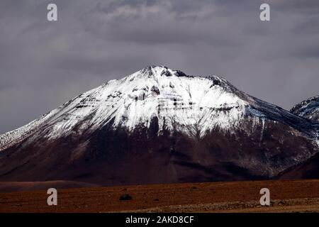 Belle cime innevate come visto dalla strada Ruta 27 che va da San Pedro do Atacama a Paso Jama, Antofagasta, Cile Foto Stock