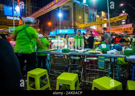 Bangkok/Thailand-December 2019: tipico lato strada ristorante a Chinatown con poche sedie verdi e camerieri in attesa per i clienti di sedersi. Foto Stock