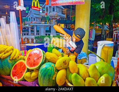 PATONG, Tailandia - 1 Maggio 2019: il venditore di succhi di frutta freschi in Banzaan freschi di mercato ghiaccio prepara cocktail di frutti tropicali (banana, mango, papaya Foto Stock