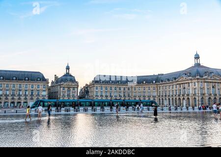 Bordeaux, Francia - 13 Giugno 2017: la gente cammina sul vicino a specchio di acqua fontana sulla Place de la Bourse di Bordeaux, regione Nouvelle-Aquitaine, Francia. Uno Foto Stock